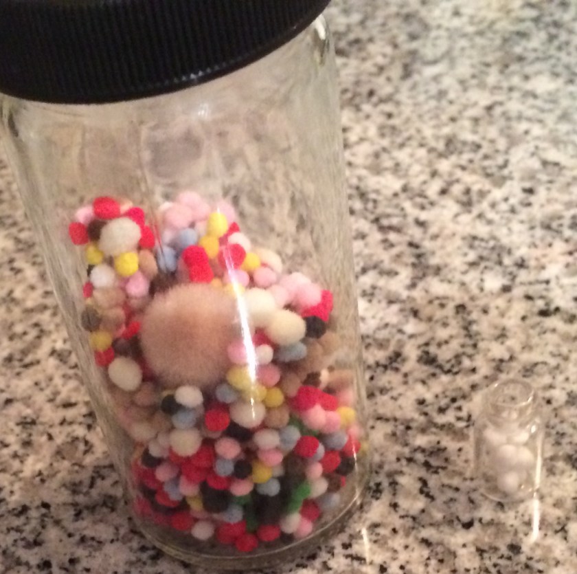 Big jar of mini pompoms beside mini jar of mini pompoms. Photo by Holly Tierney-Bedord. All rights reserved.