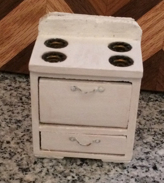 Two cork coasters, painted white, trimmed to size, and glued to the back of my little stove.