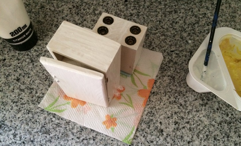 Adding coats of paint to the stove and refrigerator.