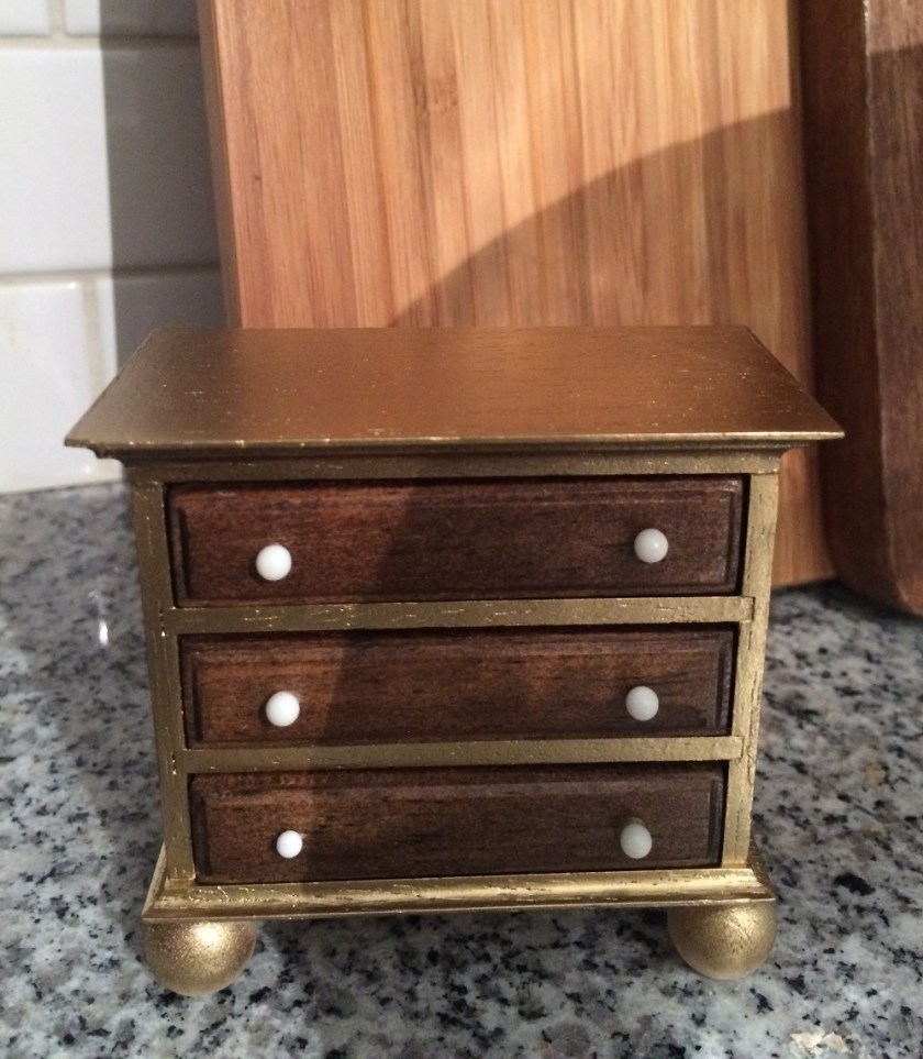 I glued wood balls to the base and spray painted it gold leaving the drawers unpainted.
